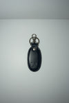 A dark navy blue leather keychain cover with a silver-tone metal clasp and keyring, featuring an embossed logo on the front, shown on a plain light background.