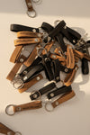 Leather loop keychains in black and tan shown side by side