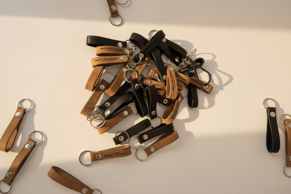 Leather loop keychains in black and tan shown side by side