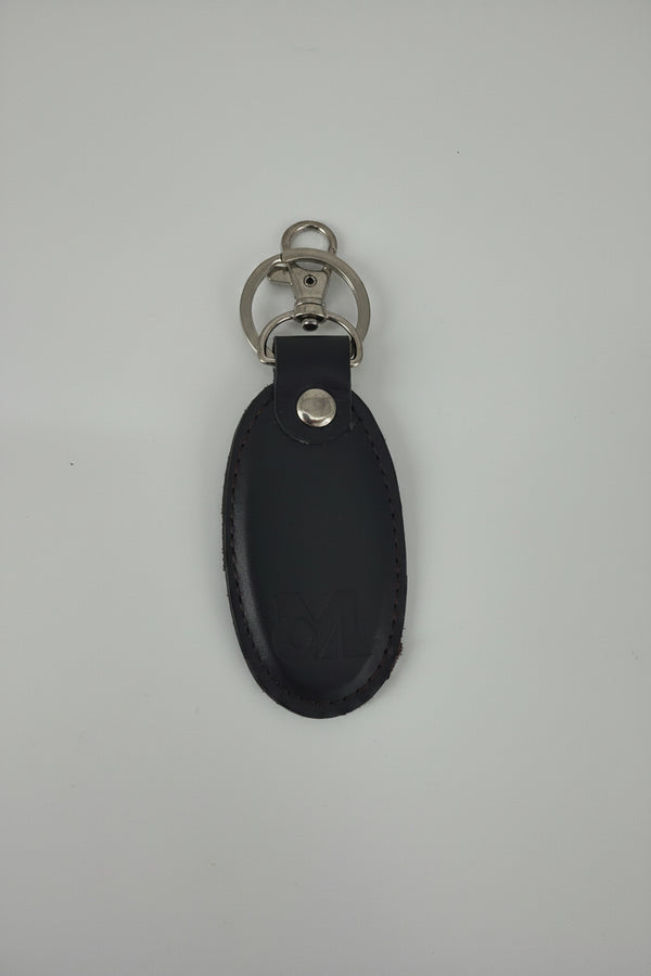 A black leather key fob or keychain with silver-tone metal rings and a snap button, shown on a plain light gray background.