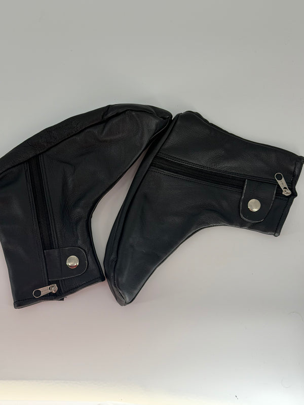 A pair of black faux leather motorcycle leg warmers with silver zipper and snap button details, displayed on a light gray background.